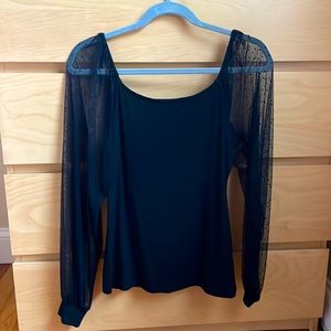 Black shirt with sheer sleeves. Super easy to dress up!